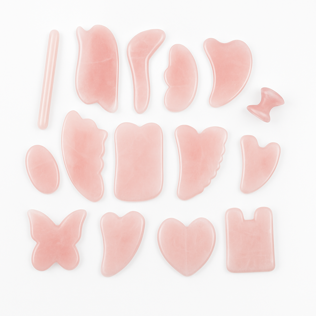 A collection of rose quartz Gua Sha tools in various shapes including heart, butterfly, and leaf, used for facial massage and skin care.